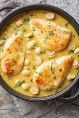 Chicken Diane in a luxuriously creamy sauce, with brandy and mushrooms closeup in the skillet on the wooden board. Vertical top view from above