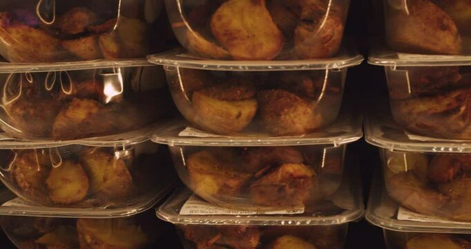 Hermetically sealed transparent plastic containers with prepared food stand on a shelf. Close-up.