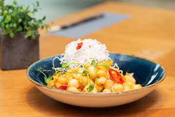 Chinese shrimps in crispy dough with chili and microgreens on a table. Balls tempura shrimps.