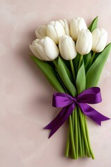 Elegant white tulips tied with violet ribbon on a soft blush pink background for special occasions