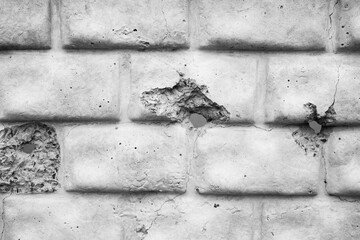 Weathered concrete wall with cracks and holes showing signs of age