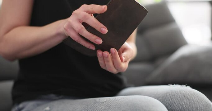 Financially struggling woman empties wallet revealing last coins. Economic hardship with deep emotional desperation symbolic concept slow motion