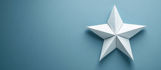 Five pointed white origami star positioned slightly right on a soft blue background, creating an elegant and minimalist aesthetic for festive design.