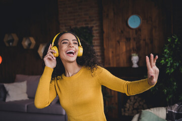 Young woman with headphones enjoying music in cozy home setting