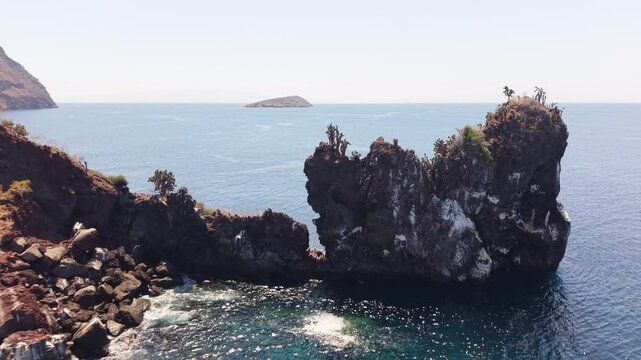 Aerial view of majestic Rock rising from the ocean, showcasing its unique shape and volcanic origin in the Galapagos archipelago