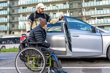 Obraz premium Caregiver helping young disabled man entering car in the city