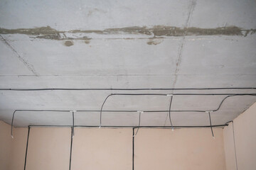 Exposed wiring and unfinished ceiling in a renovation project indoor space