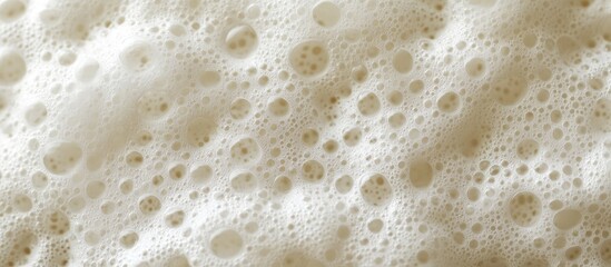 Textured macro shot of creamy colored bubble foam with intricate patterns, showcasing a soft background and varying bubble sizes for detail.