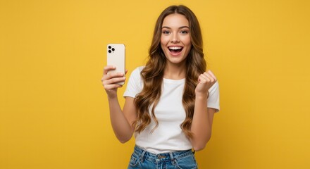 Young woman over isolated yellow background with phone in victory position