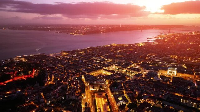 Aerial view of Lisbon at sunset showcasing vibrant city lights and the beautiful coastline