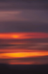 Fototapeta premium Abstract blurred background of a vibrant sunset over natural landscape with soft colors