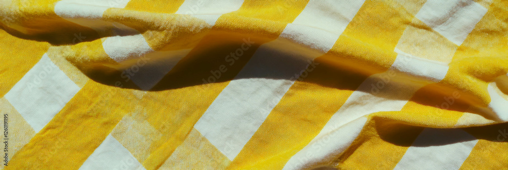 Poster crisp texture of yellow gingham tablecloth evokes warmth and charm in any setting