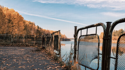 autumn landscape river and pier with a sunken destroyed house in Chernobyl