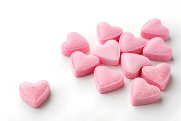 Obraz premium The image shows pink heart-shaped candies on a white background. 