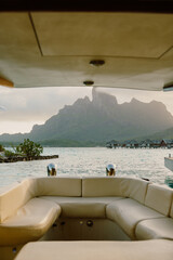 A luxurious tropical getaway featuring a wooden boat docked under a thatched-roof pavilion,...