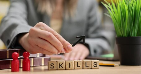 HR manager holds upward arrow over word Skills on desk. Woman shows career growth and development at contemporary office workspace slow motion
