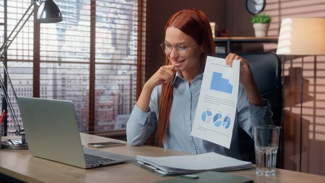 Smiling success company CEO manager talking video call conference laptop in office businesswoman Caucasian business woman girl female showing diagram good result marketing corporate growth stats data