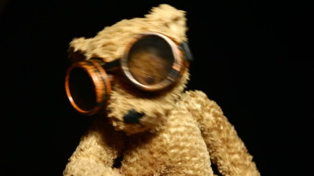 footage of plush bear goggles glasses dark background