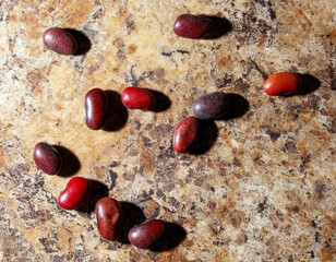 A bunch of red beans are scattered on a brown surface