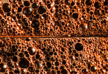 Macro of bubbly cellular dark chocolate, showing its unique airy texture and rich bronze color....