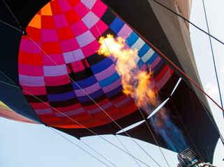 Obraz premium A hot air balloon with a red and orange striped body is floating in the sky