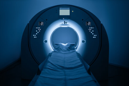 Medical CT or MRI Scan in the modern hospital laboratory. Interior of radiography department. Technologically advanced equipment in white room. Magnetic resonance diagnostics machine. Blue backdrop