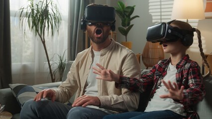 Caucasian family playing virtual reality game wearing 3d glasses helmets VR experience modern technology at home amazed wonder together man male dad father online with little girl daughter child kid © Yuliia