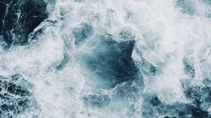 Fototapeta premium Aerial view of turbulent ocean waves, showcasing the vibrant contrast between deep blue water and white frothy surf.