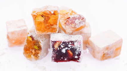 Sweet food Turkish delight, assorted rahat locum in form of cubes with nuts and powdered sugar, traditional food, on white background