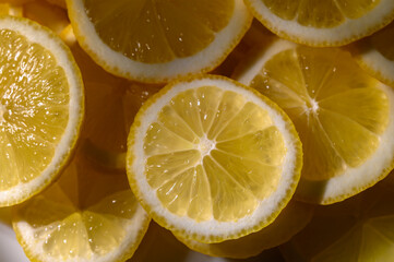 Freshly sliced lemons arranged artistically on a vibrant surface in a sunny kitchen setting