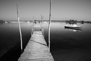 Wooden pier and boats anchored in Mimbeau lagoon off Cap Ferret, Arcachon, Gironde department, Nouvelle-Aquitaine, France, Europe
