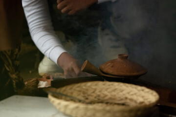 An Indonesian woman bakes cakes on a stove. The activity of cooking traditional cakes on a clay stove
