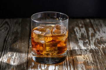 Enjoying a refreshing glass of whiskey on a rustic wooden table in the evening light