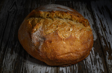 Freshly baked artisanal bread resting on a rustic wooden surface in a cozy home kitchen at dusk