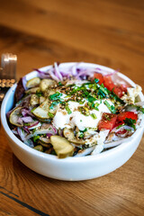 Salad bowl on wooden table background. Delicious healthy vegetable salad made from eco products