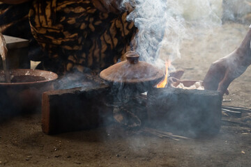 An Indonesian woman bakes cakes on a stove. The activity of cooking traditional cakes on a clay...