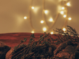 Stones with dried flowers on an old wooden background and lights at night for a romantic vintage background.     