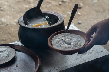 An Indonesian woman bakes cakes on a stove. The activity of cooking traditional cakes on a clay...