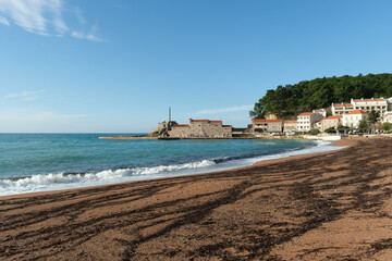 Mediterranean coastal town and beach with a mountain backdrop.