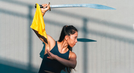 Chinese young woman practicing wushu kung fu with weapons outdoor. Young girl training martial arts...