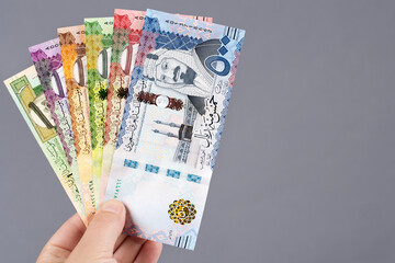 Saudi money in the hand on a gray background