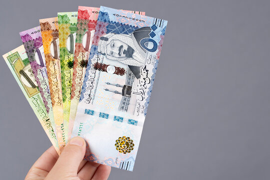 Saudi money in the hand on a gray background