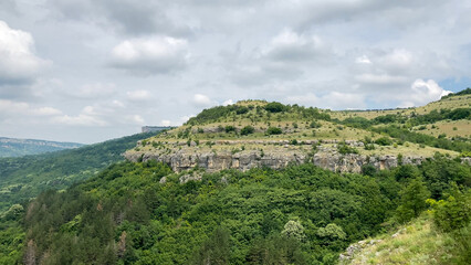 Scenic view of Garga Bair Hill, Bulgaria. Lush green hills and rocky cliffs meet a cloudy sky - Veliko Tarnovo, Bulgaria, Europe