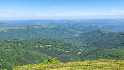 Scenic view of green forested mountains, meadows, and hills under blue sky in the Balkan Mountains, Bulgaria - Europe