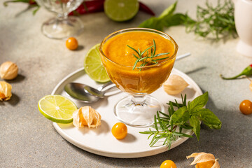 Delicious cape gooseberry sauce with lime and rosemary on a table