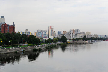 Fototapeta premium Stunning cityscape reflected in calm river waters. Modern older buildings line the waterfront.