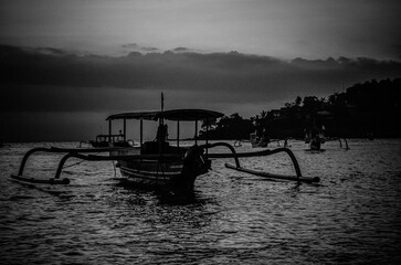Silhouette of a Traditional Boat at Dawn on Calm Waters