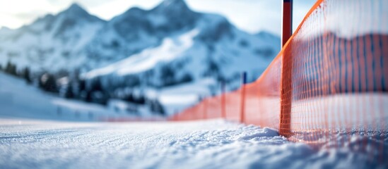 Slalom gate on alpine ski course with blurred slope and snowy mountains in background creating empty space for text or branding.