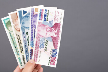 Old Turkish money in the hand on a gray background
