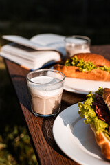 croissants with filling in a cafe on the street, croissants with ham, smoked chicken, lettuce, sauce, caffè latte, French lunch, fast healthy food, pastries, coffee at sunset, wooden background
